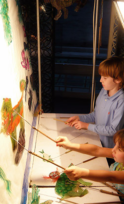 Children manipulating shadow puppets.