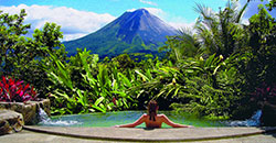 Woman in Outdoor Pool with Volcano in Costa Rica.